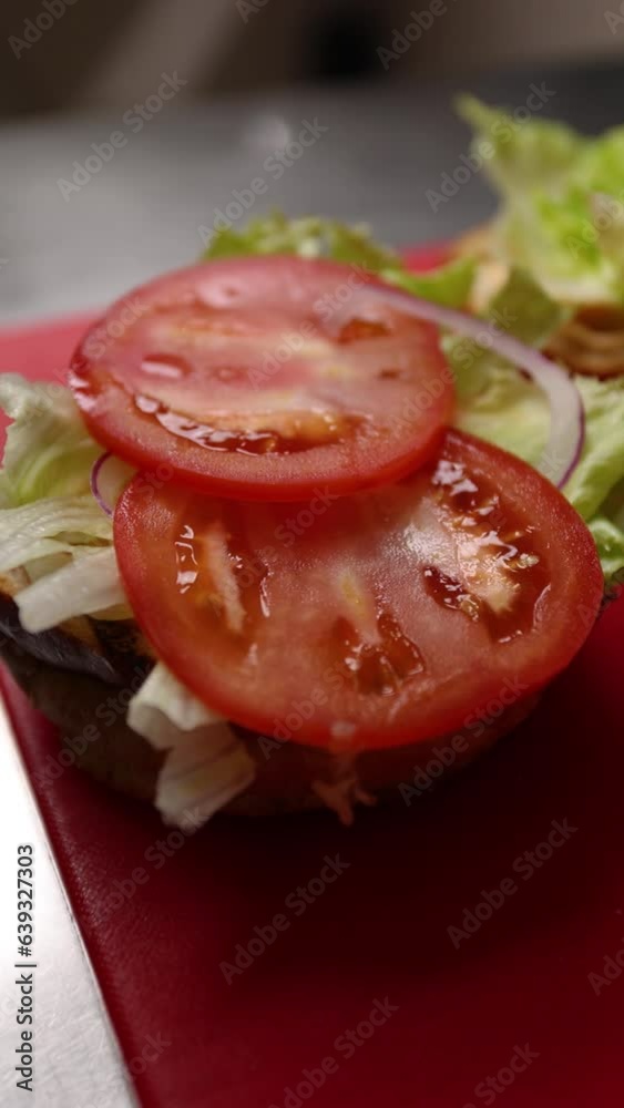 The chef prepares a delicious hamburger. Close-up The chef prepares a delicious hamburger. Close-up