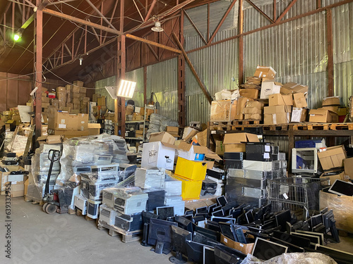 Sorting electronic waste for recycling. Cell phone photo of a warehouse.