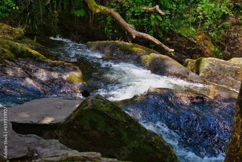 at the back of small waterfall in the forest at Rhaeadr Nantcol Waterfalls, UK photo