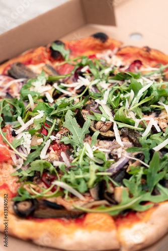 Close-up of an Italian pizza with cheese, mushrooms, onions, tomatoes, and herbs, food photo
