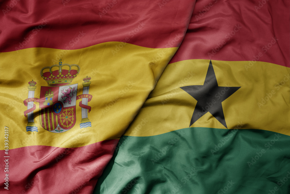 big waving national colorful flag of spain and national flag of ghana . big waving national colorful flag of spain and national flag of ghana .