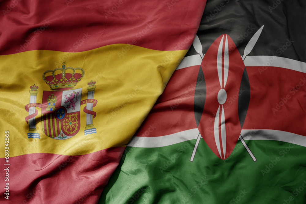 big waving national colorful flag of spain and national flag of kenya .