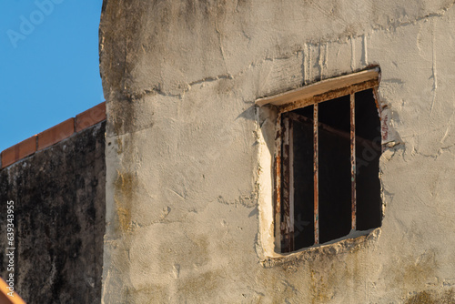 House window with iron bars resembles prison cell from street  from where every day there is less and less hope for release  review criminal case  acquittal and release. Innocently convicted concept