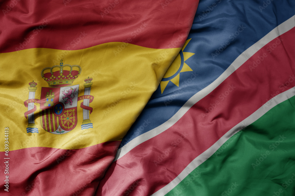 big waving national colorful flag of spain and national flag of namibia .