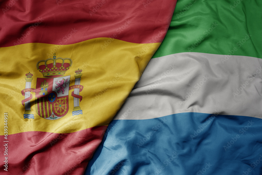 big waving national colorful flag of spain and national flag of sierra leone . big waving national colorful flag of spain and national flag of sierra leone .