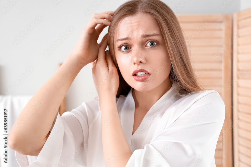Shocked young woman with hair loss problem at home Shocked young woman with hair loss problem at home