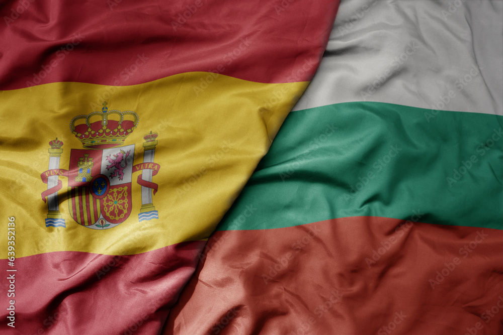 big waving national colorful flag of spain and national flag of bulgaria .