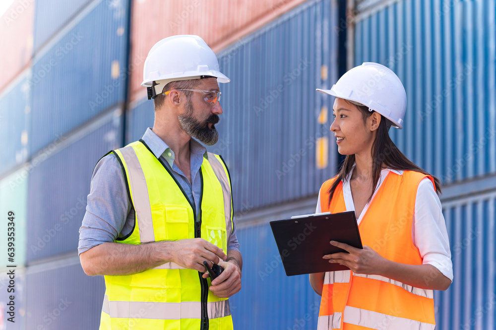 Asian dock control man and woman logistics worker wear safety helmets and protect suite working in shipping container, commercial transport background.
