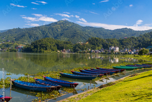 Beautiful Green Phewa Lake with Boats and Green Mountains in Pokhara City of Nepal during monsoon photo