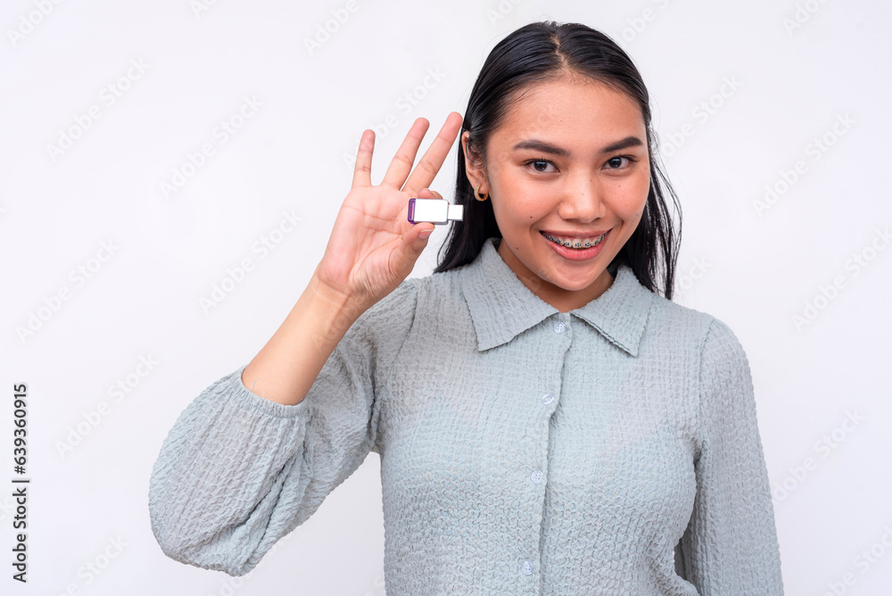 A happy young asian woman holding a usb flash drive. Isolated on a white background. A happy young asian woman holding a usb flash drive. Isolated on a white background.