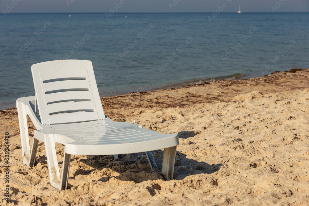 white plastic lounger on the background of the sea