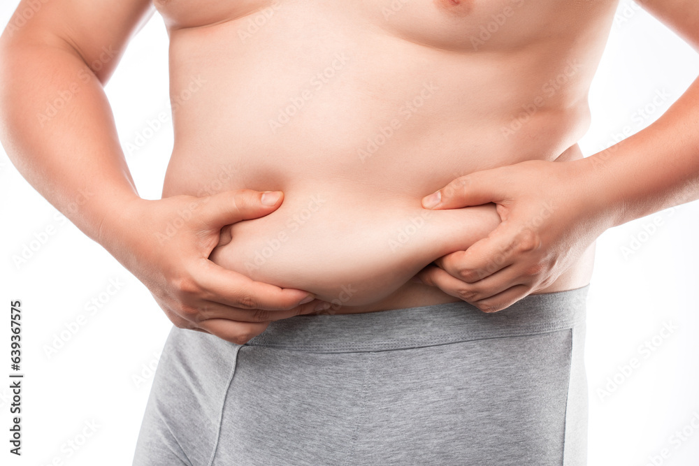 A fat man in grey underwear shows fat deposits in the abdomen and thighs. The concept of not proper nutrition, sedentary lifestyle. Overweight treatment.