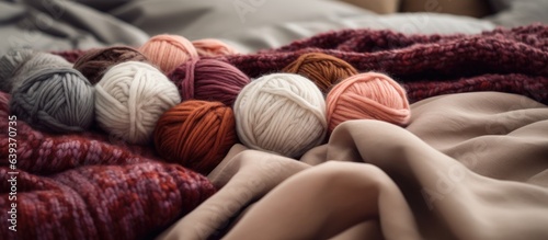 Yarn balls and a wool blanket on the bedspread photo