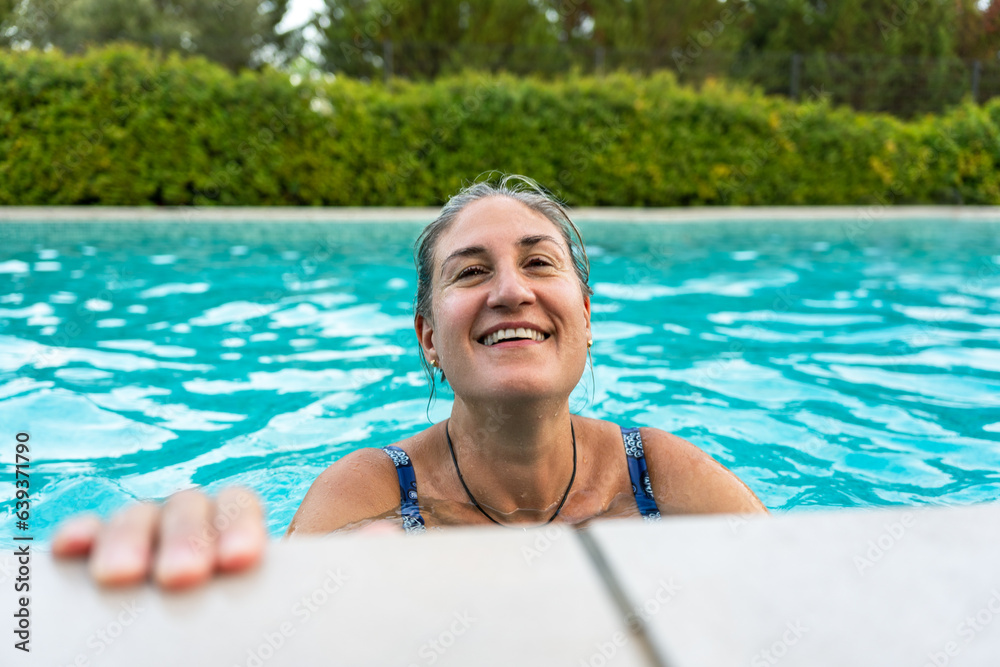 A smiling woman in a swimming pool.