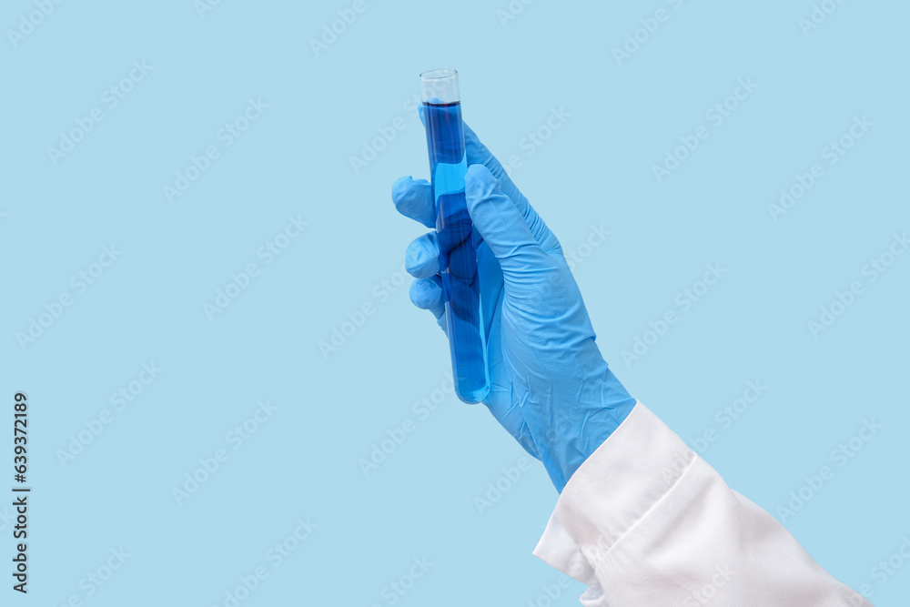 Lab's worker hand with test tube of sample on blue background Lab's worker hand with test tube of sample on blue background