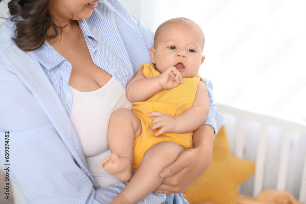 Young woman with her baby in bedroom, closeup Young woman with her baby in bedroom, closeup