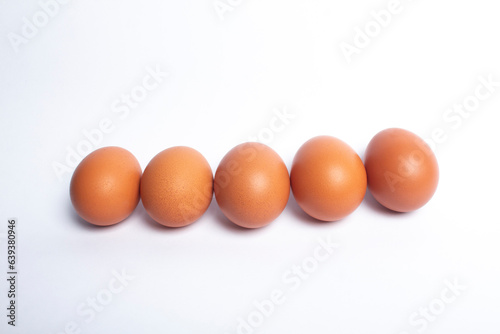 photo of chicken eggs in a row isolated on a white background