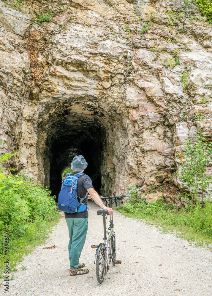 Senior man with a folding bike on Katy Trail at a tunnel near Rocheport