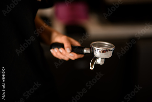 Professional holder for ground coffee in female hand. Tools for preparing coffee in coffehouse or restaraunt.