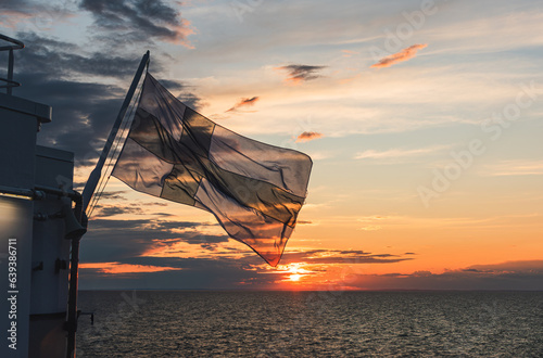 flag of Finland over the Gulf of Bothnia on the background of sunset photo