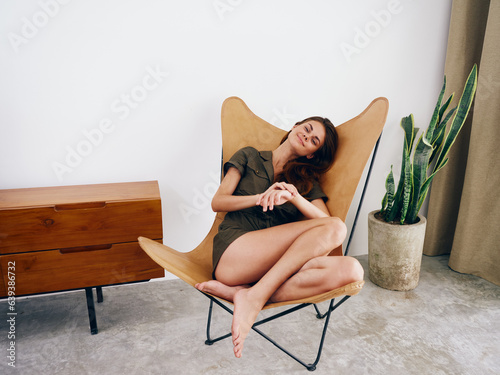 Woman sitting on a chair at home beautiful smile, fun and relaxation, modern stylish interior scandia lifestyle, copy space.
