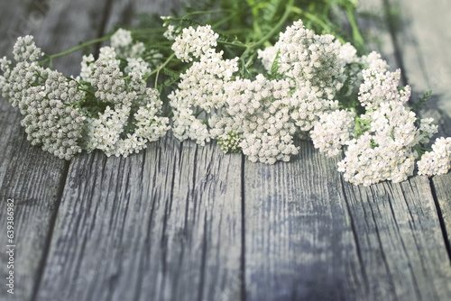 bouquet of wild flowers on a wooden background close-up. a bouquet of yarrow flowers. simple background with wildflowers.