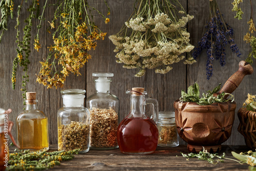 Bottles of tinctures and oils with dry herbs in a pantry