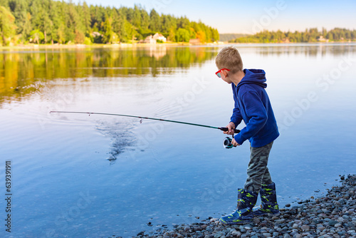Boy fishing on a lake at sunset. Puget Sound Washington state 