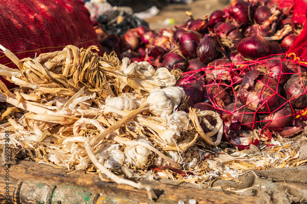 Garlic and red oniions at an outdoor market.