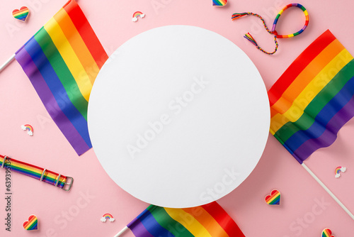 Commemorate LGBTQ+ Pride Month in July. A captivating top-down image of empty circle, surrounded by LGBTQ+ flags and symbols on a pastel pink isolated background, perfect for ads or text overlays