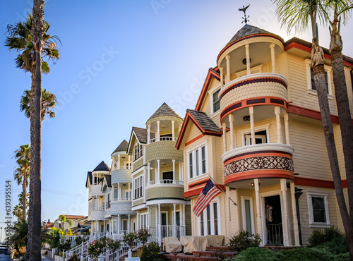 Ornate old Victorian houses on a street lined with palm trees in Huntington Beach, Orange County, California famous for surfing
