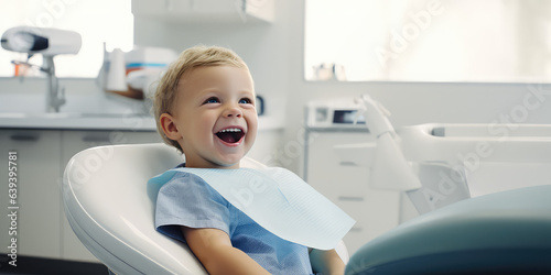 Smiling baby lying in dentist chair exposing white teeth. Creative banner with happy baby for pediatric dentistry. photo