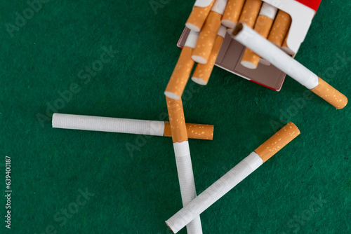 few cigarettes with filter closeup on green background