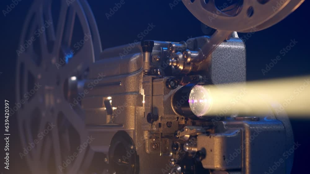 Close up view of old vintage movie projector playing film and camera move around it. 16mm retro projector. The concept of old film or cinema. beam of light illuminates in dark.