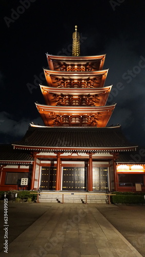Photos Nighttime views of a traditional Japanese pagoda illuminated in warm light, show