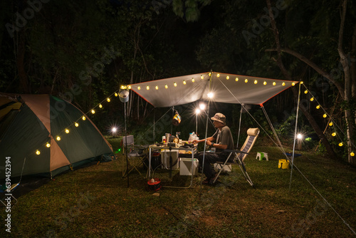 Outdoor camping tent with tarp or flysheet and Tent lighting, camping tent in the forest under night sky.