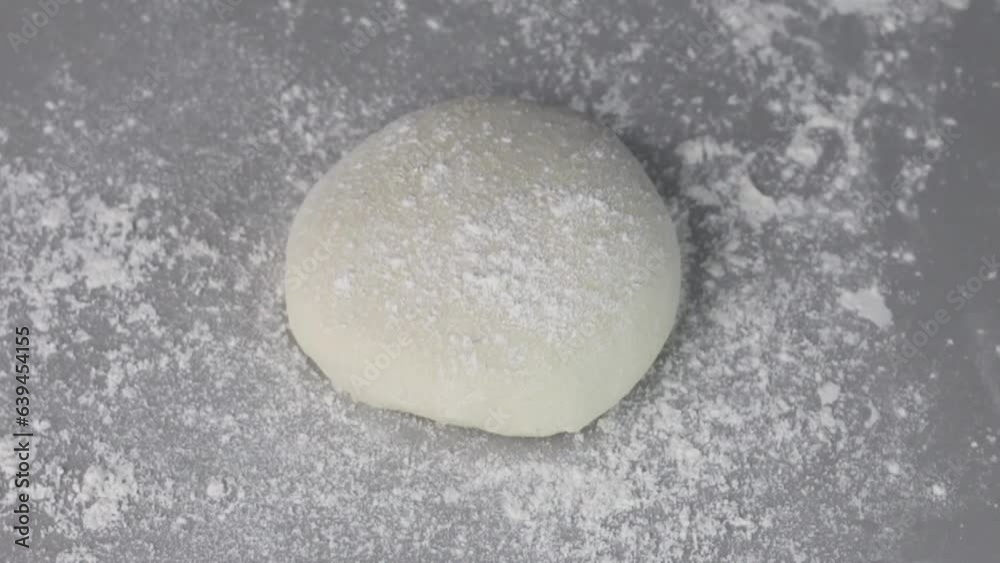Pouring urine Risen or proved yeast dough for bread or pizza on a floured slate surface, video overhead with Selective Focus Pouring urine Risen or proved yeast dough for bread or pizza on a floured slate surface, video overhead with Selective Focus