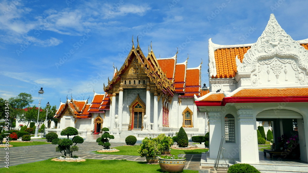 herrlicher buddhistischer Tempel Wat Benchabophit in Bangkok aus weißem Marmor mit Eingangstor und grünen Pflanzen