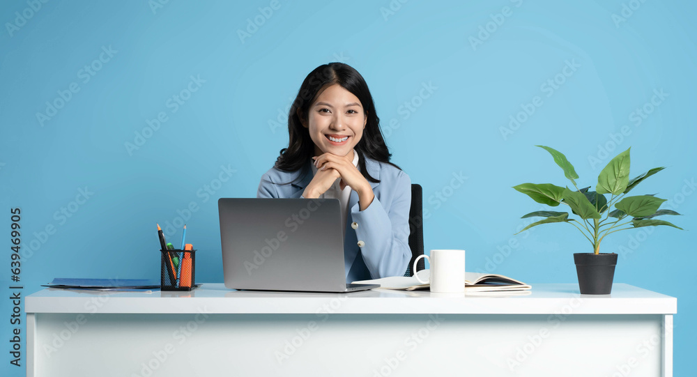 image of asian businesswoman sitting and using laptop on desk image of asian businesswoman sitting and using laptop on desk