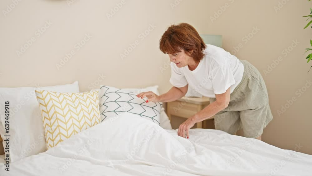 Middle age woman make bed at bedroom Middle age woman make bed at bedroom