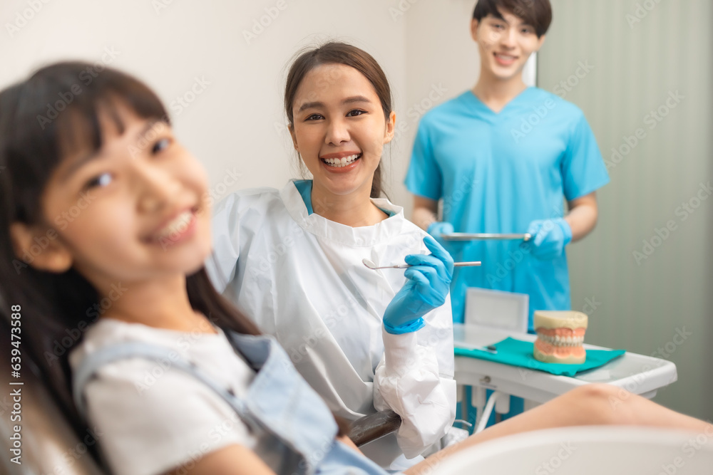 Children's dentistry for healthy teeth .Close-up happy little child asian girl smiles looking at camera, sitting in dentist's chair, receiving dental. Children's dentistry for healthy teeth .Close-up happy little child asian girl smiles looking at camera, sitting in dentist's chair, receiving dental.