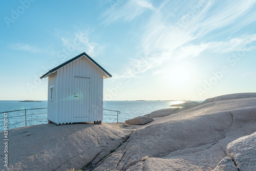 A small white beach hut and a beautiful coastal scenery