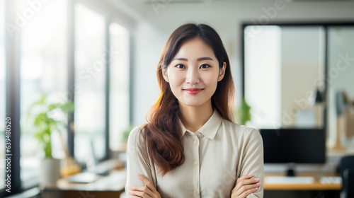 A Casual portrait of a designer in her office standing by her desk, daylight coming through the window, corporate photography, Asian woman. © Phoophinyo