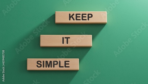 Keep it simple words on wooden blocks. Business copywriting concept.3D rendering on green background.
