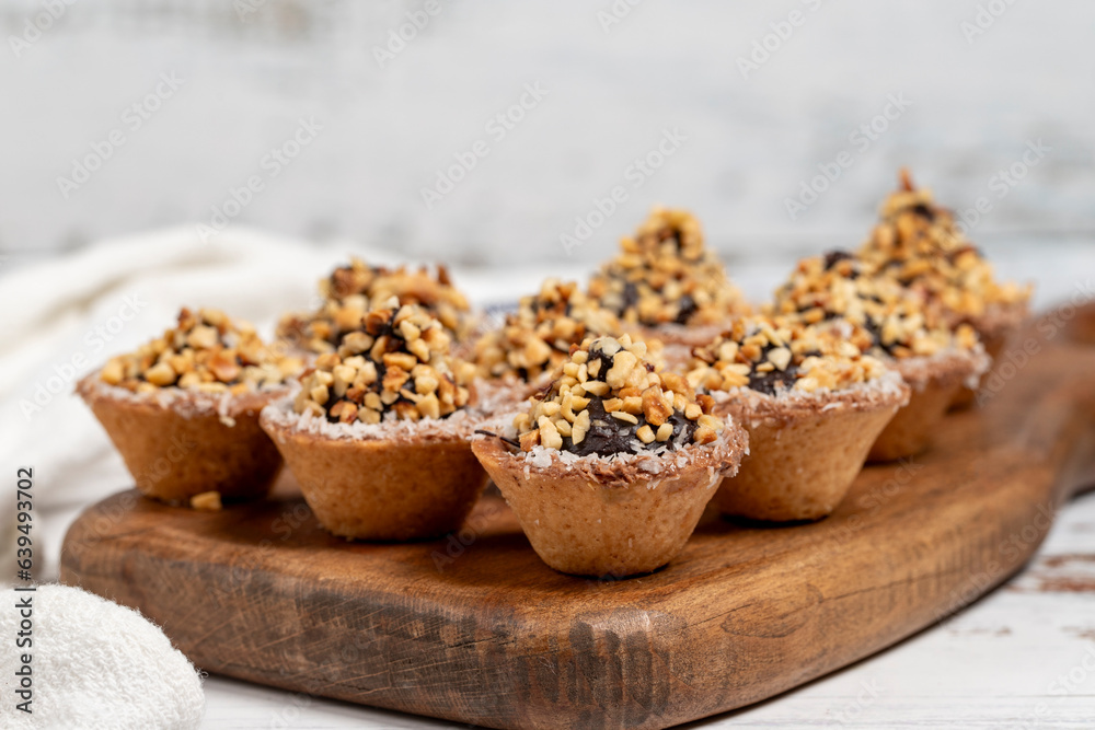 Tart cookies. Delicious mini tartlets with chocolate cream and nuts on a white background Tart cookies. Delicious mini tartlets with chocolate cream and nuts on a white background