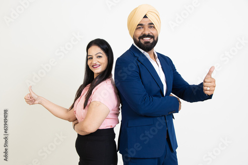 Young successful indian sikh business man and woman wearing formal dress do thumbs up isolated over white background.