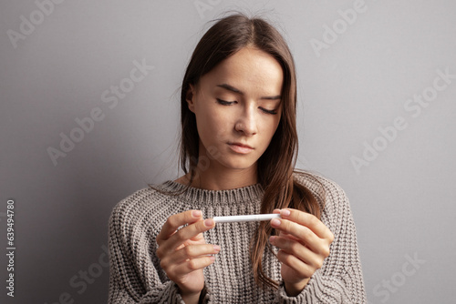 Obraz na plátně teenager girl looks at a cigarette, stop smoking, tobacco addiction of minors, c