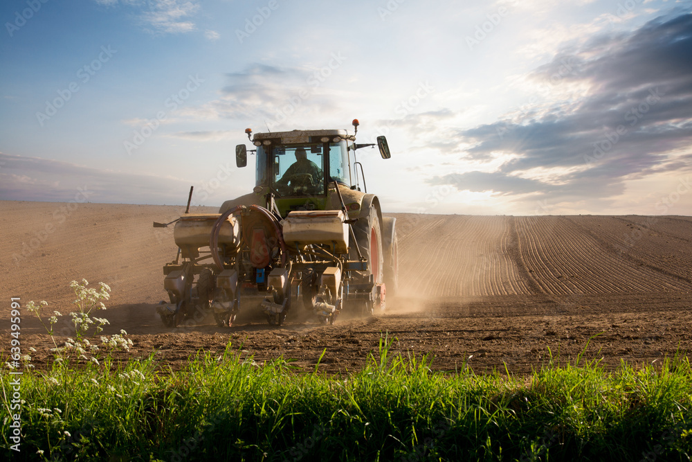 Obraz premium Tracteur et agriculteur au travail dans les champs pendant les semailles.