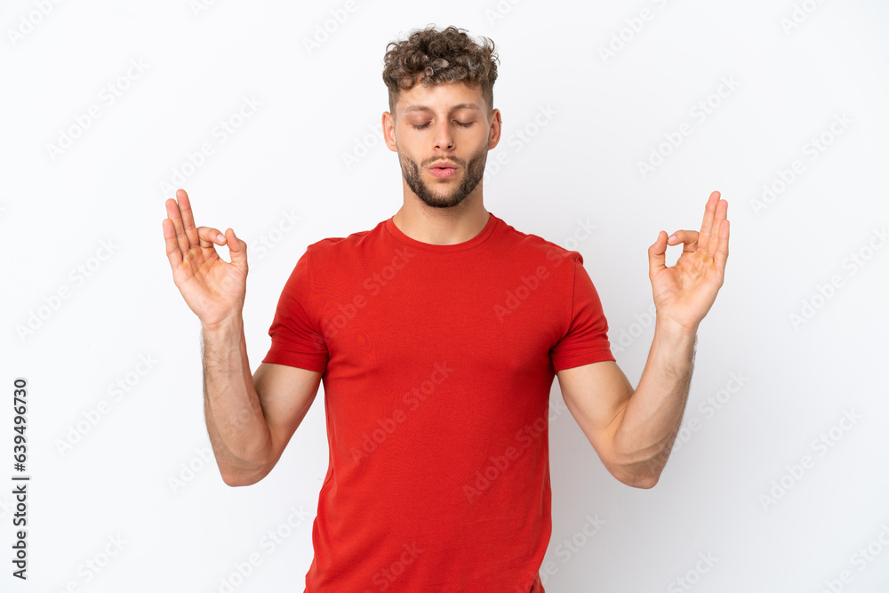 Naklejka premium Young caucasian handsome man isolated on white background in zen pose