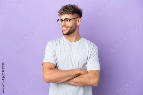 Delivery caucasian man isolated on purple background happy and smiling